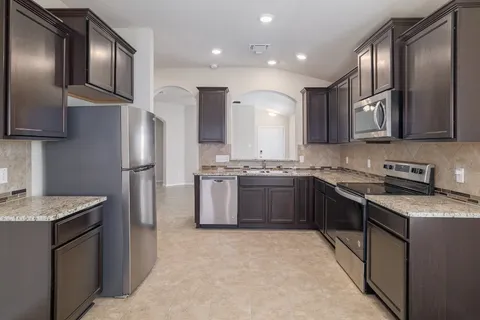 a kitchen with a refrigerator sink and cabinets
