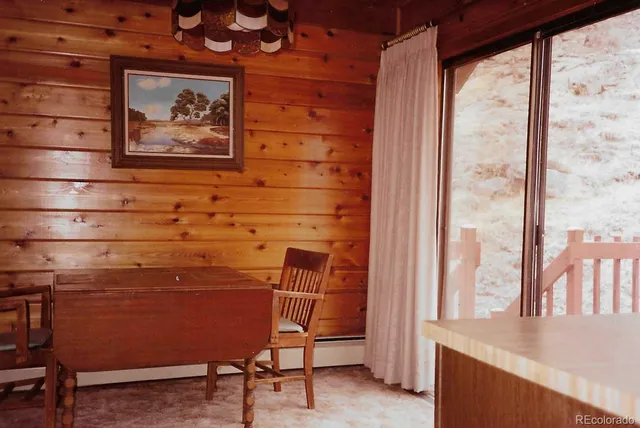 a view of a room with wooden walls and a window