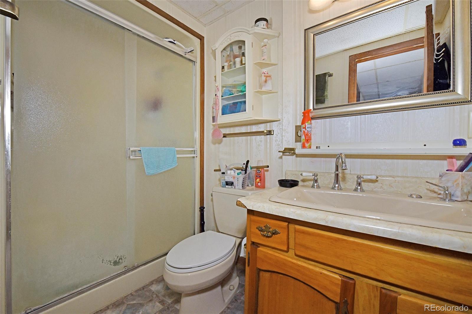 79 Ranch View Drive Florissant, CO 80816 - Photo 27 of 40 a bathroom with a granite countertop toilet sink and mirror