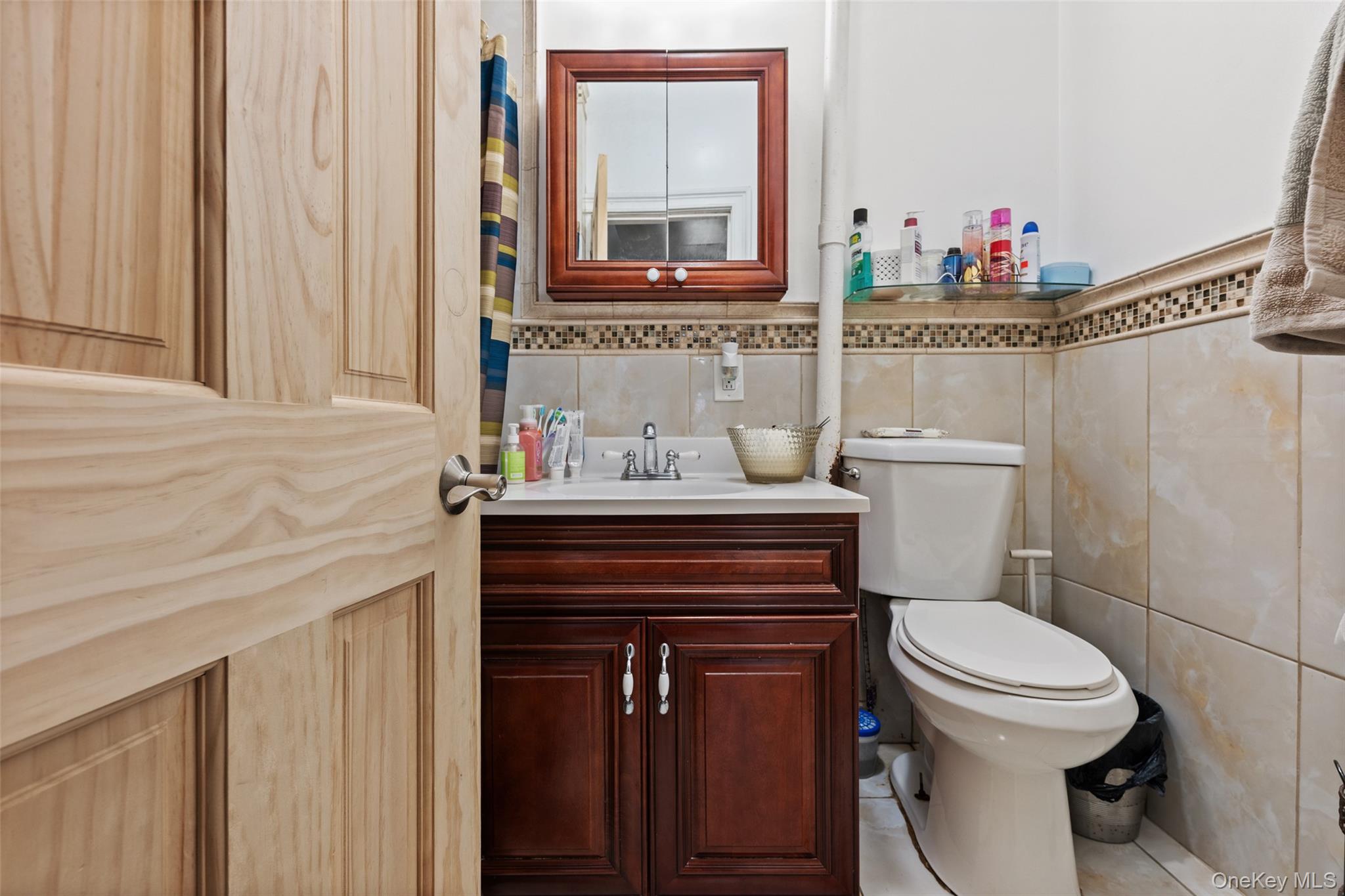 3158 Decatur Avenue Bronx, NY 10467 - Photo 6 of 7 a bathroom with a sink a toilet and a mirror