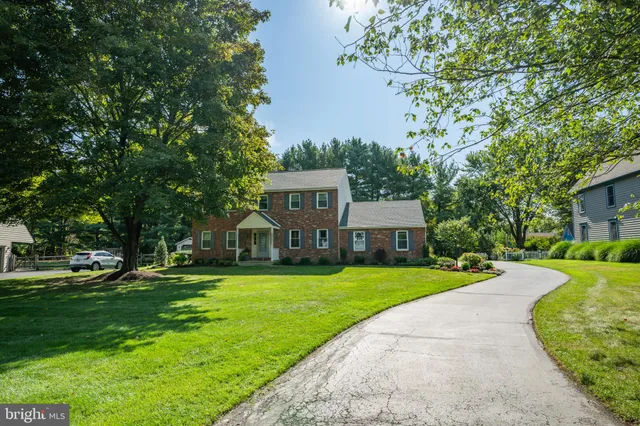 a front view of a house with a yard and trees
