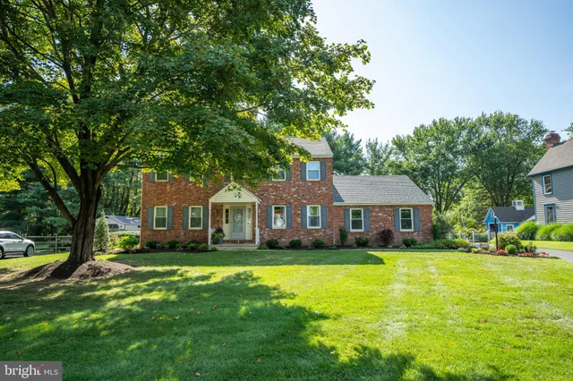 a front view of a house with a garden and trees