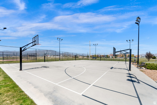 6120 North Sheps Ridge Road Eagle Mountain, UT 84005 - Photo 30 of 43 Outdoor basketball court featuring two hoops with backboards, court markings, and perimeter fencing