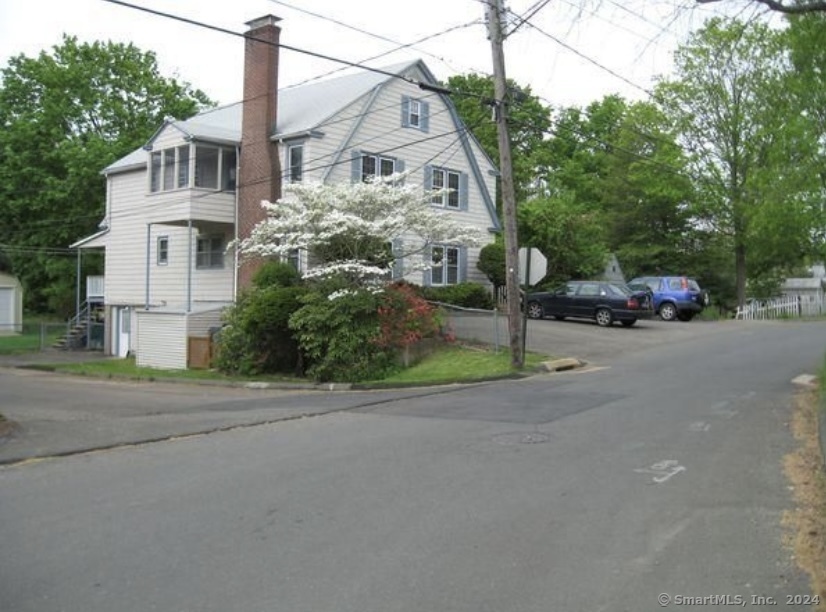 a front view of a house with a garden and tree