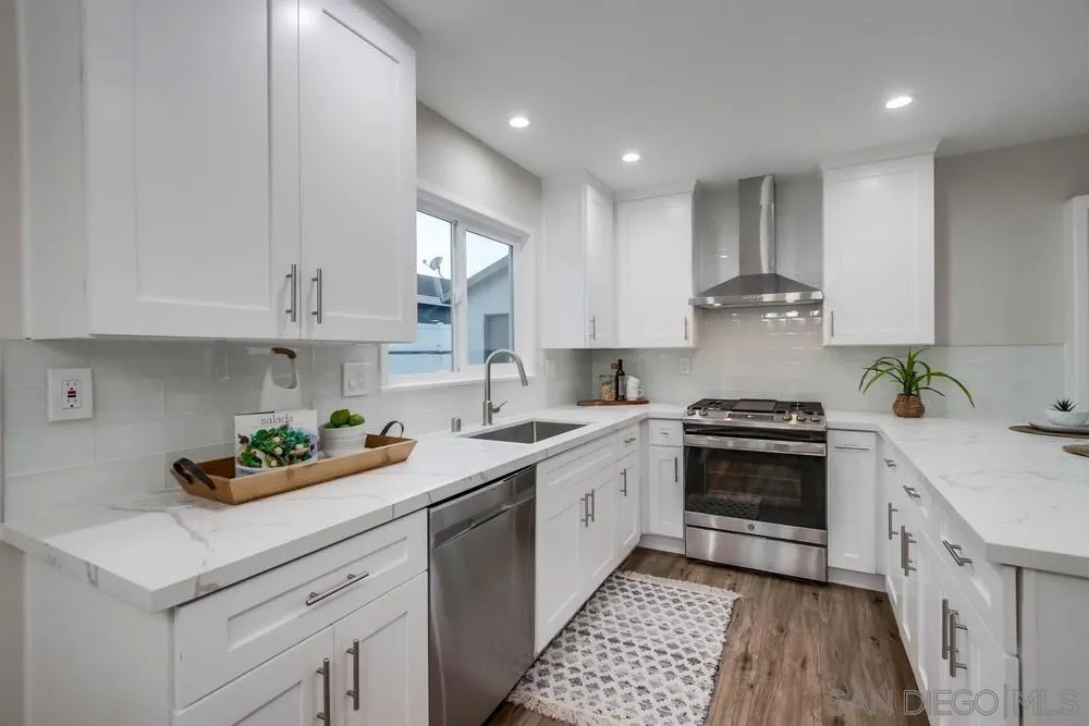 4534 Kamloop Avenue San Diego, CA 92117 - Photo 19 of 36 a kitchen with stainless steel appliances granite countertop a sink stove and cabinets