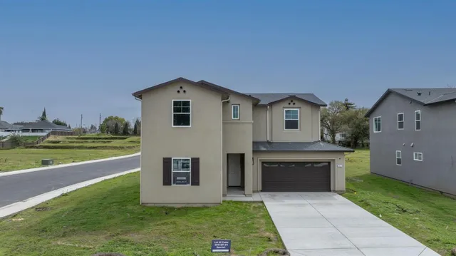 a front view of a house with a yard and garage