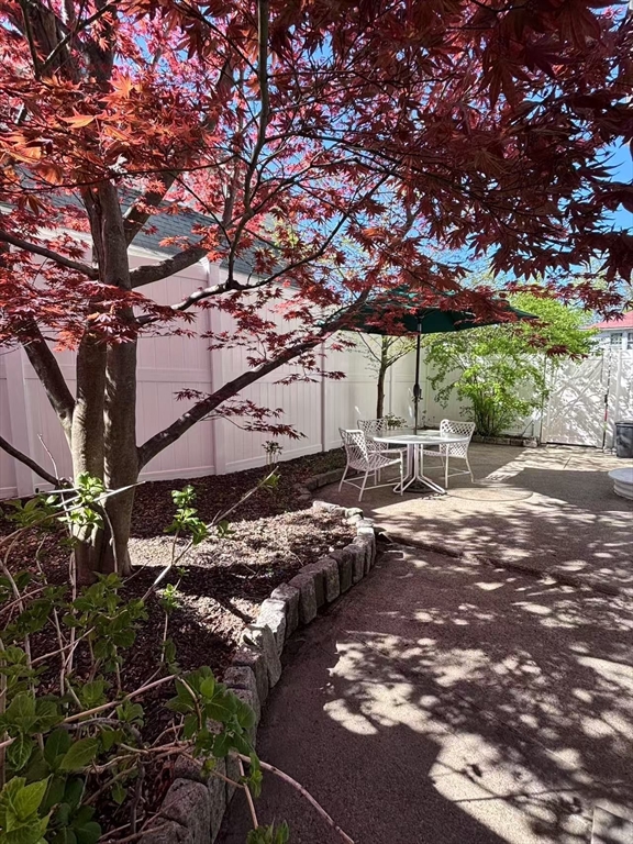 11 Sessions Street Wellesley, MA 02482 - Photo 22 of 22 a backyard of a house with table and chairs under an umbrella