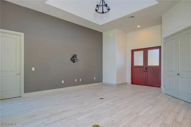 an empty room with wooden floor and mirror