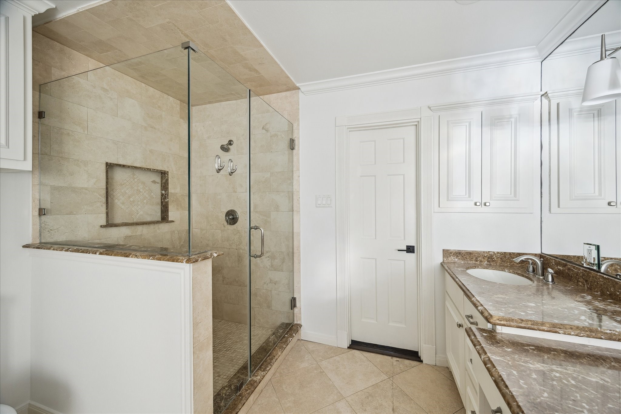 3049 Locke Lane Houston, TX 77019 - Photo 11 of 30 This absolutely breath-taking primary bath is completed with an incredible, sleek walk-in shower complete which pairs perfectly with the oversized built-in bathtub. Wrap-around built-ins are perfect for storing towels and bath products.