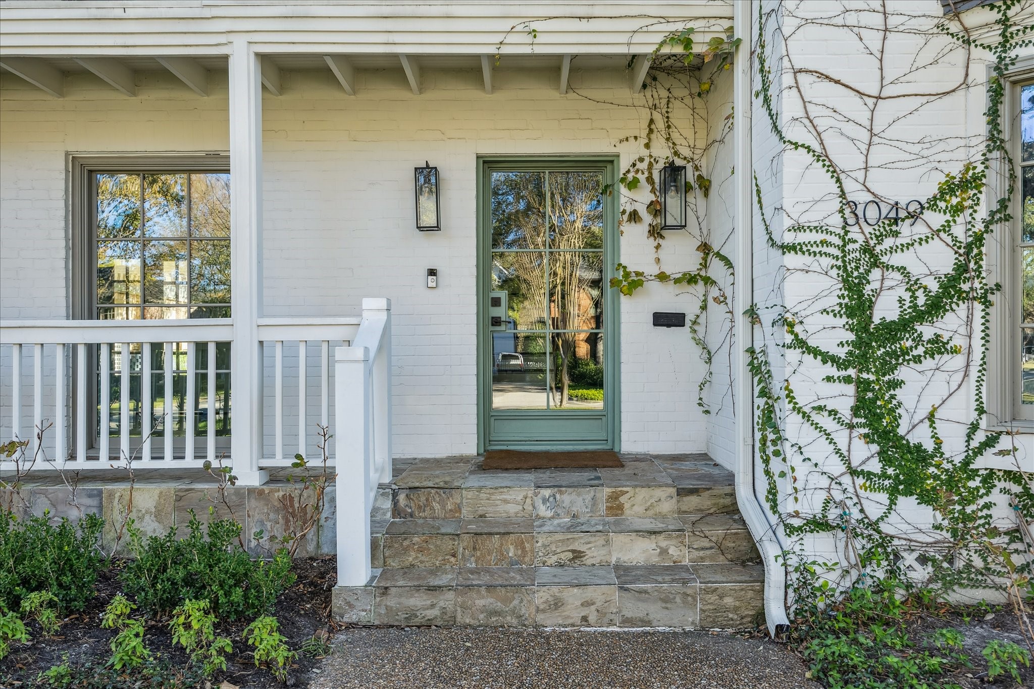 3049 Locke Lane Houston, TX 77019 - Photo 2 of 30 The home’s exterior boasts a beautiful, glass front door perched on the top of the porch steps. Notice the impressive landscaping & hardscaping which make this one-of-a-kind property warm and inviting.