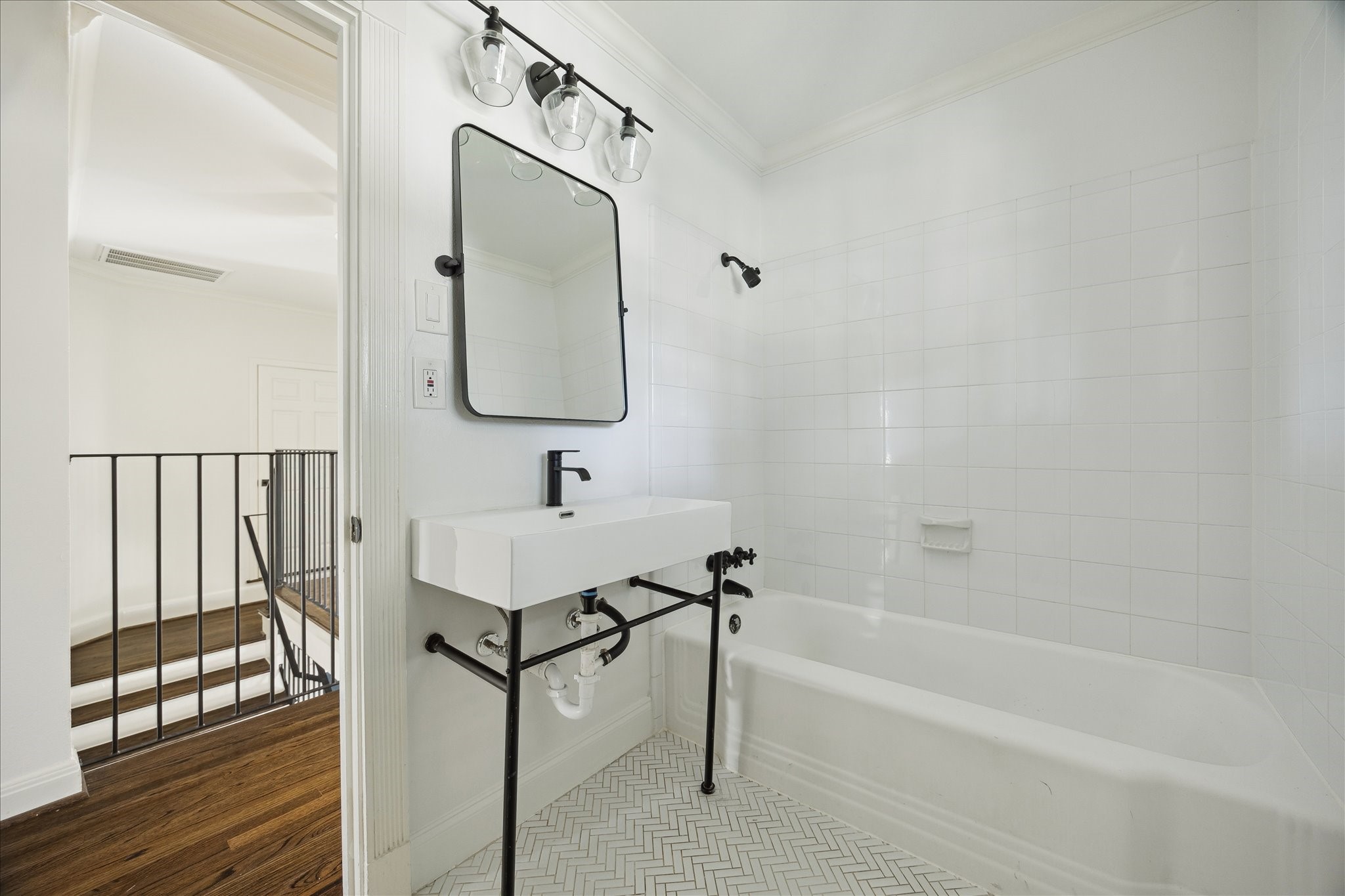 3049 Locke Lane Houston, TX 77019 - Photo 26 of 30 The two spacious secondary bedrooms share this charming bath with a modern sink and large shower & tub combo. Subway tile and chevron tile floors create a sleek and contemporary feel for the space.