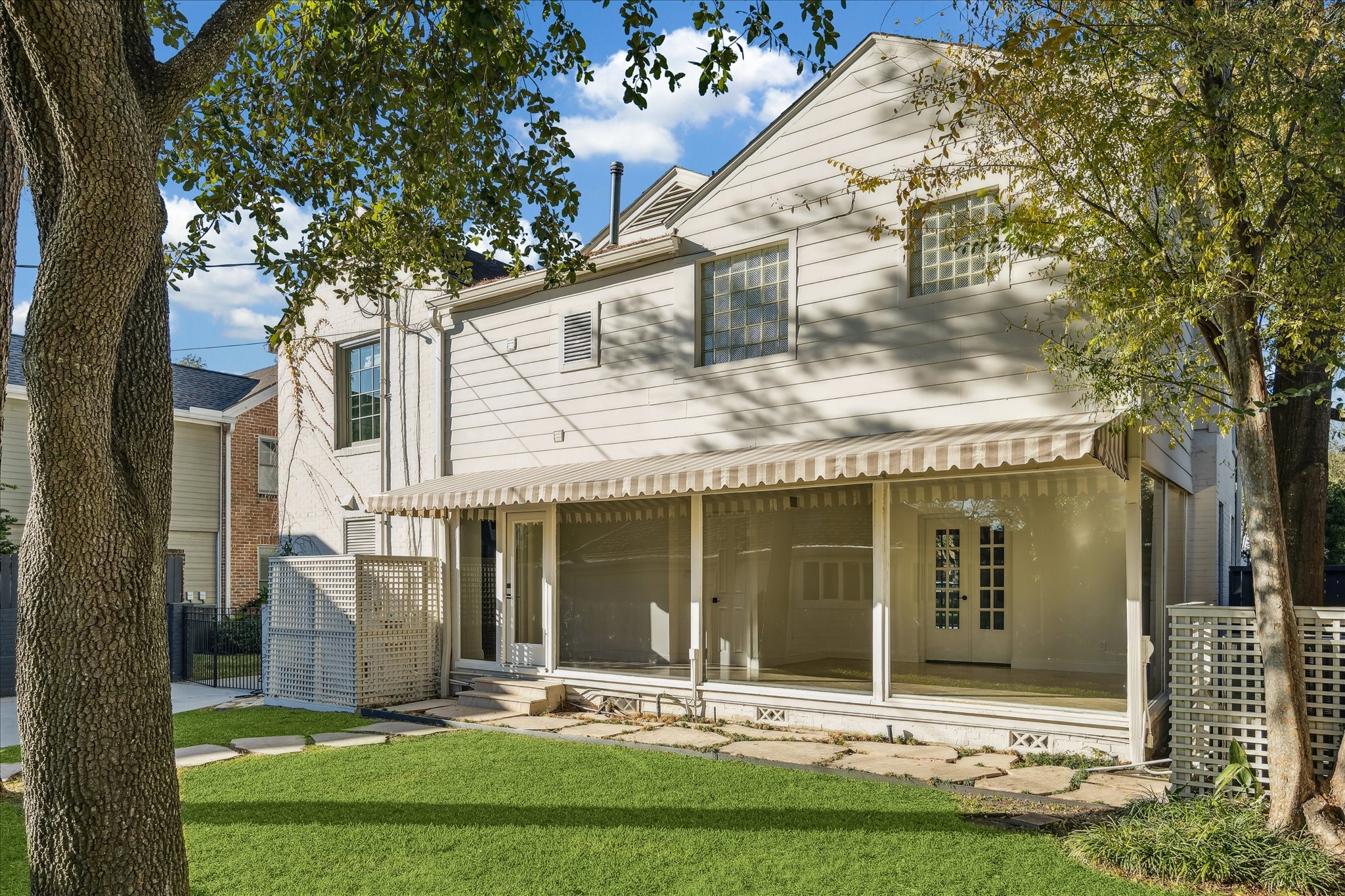 3049 Locke Lane Houston, TX 77019 - Photo 27 of 30 The backyard is peaceful and features mature trees and a beautiful awning that adds a retro flair to this incredible home.