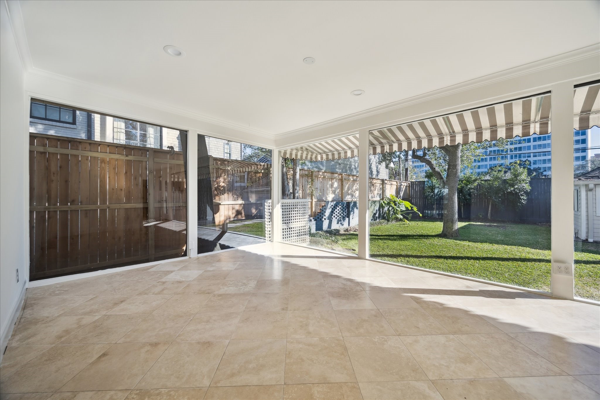 3049 Locke Lane Houston, TX 77019 - Photo 7 of 30 Walls of floor-to-ceiling windows in the fantastic family/sun room look out onto the backyard. This is a perfect space to create a casual sitting room or work from home office.