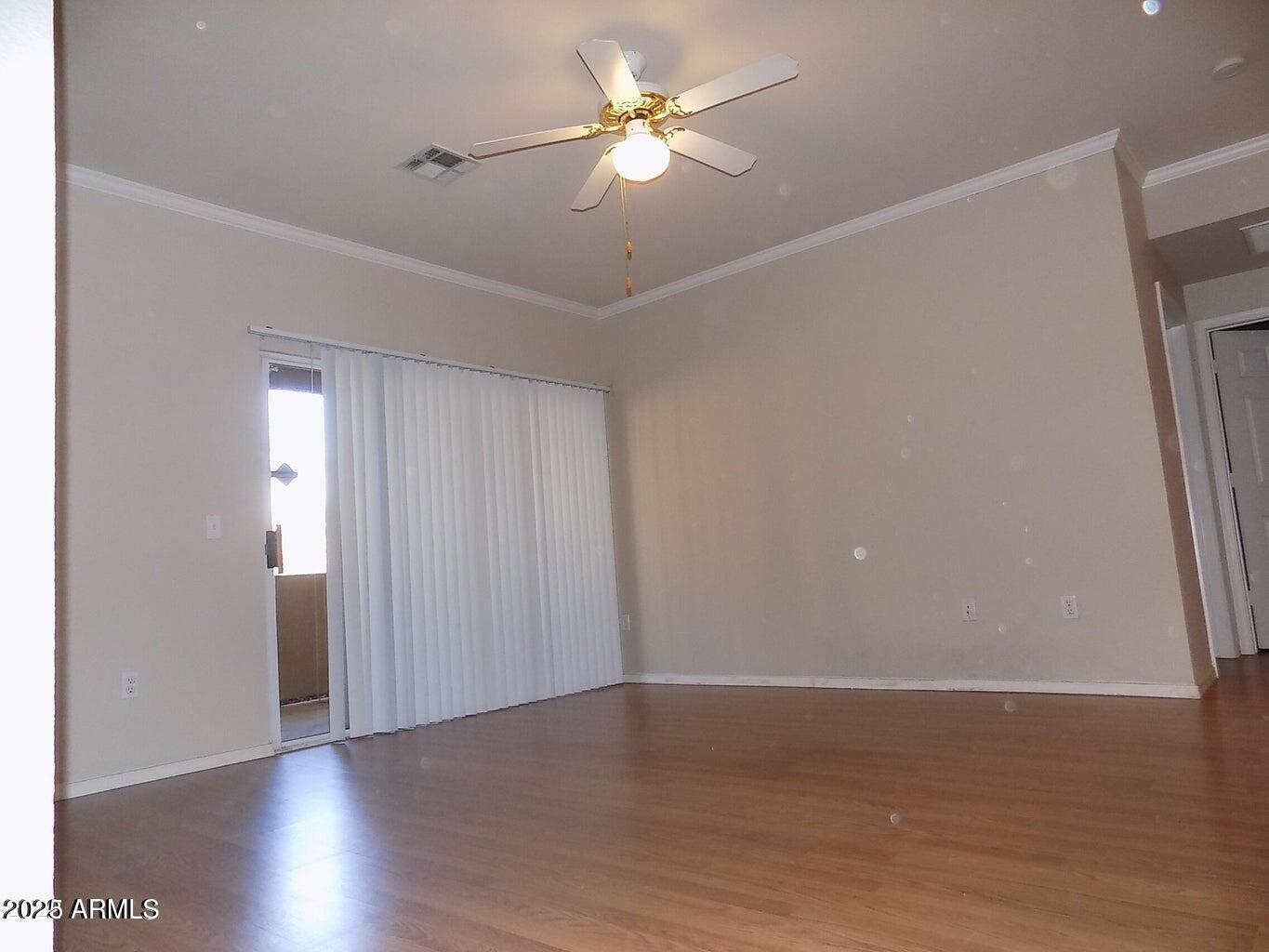 5401 East Van Buren Street, Unit 1027 Phoenix, AZ 85008 - Photo 3 of 23 a view of a room with wooden floor and a ceiling fan