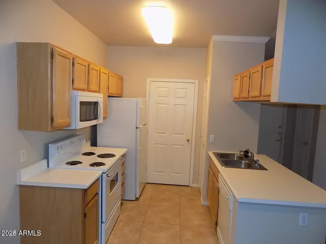 a kitchen that has a sink a stove and a refrigerator