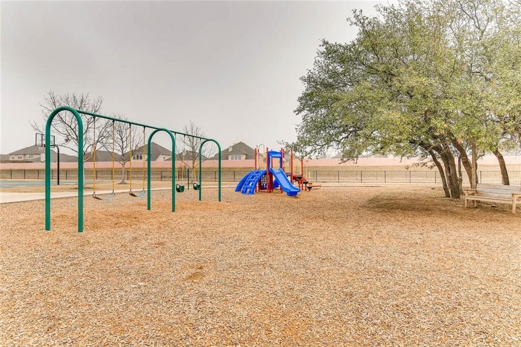 2109 Granite Springs Road Leander, TX 78641 - Photo 30 of 30 A community playground, complete with swings and a colorful slide structure, offers recreational space.