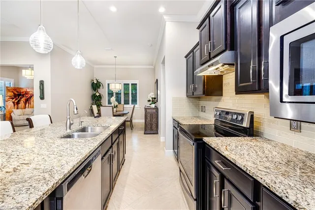 a kitchen with granite countertop stainless steel appliances a sink counter space cabinets and wooden floor