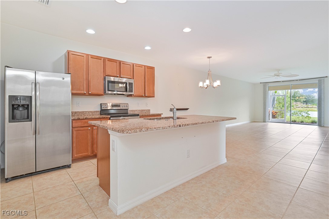 15239 Ligustrum Lane Alva, FL 33920 - Photo 23 of 44 a kitchen with kitchen island granite countertop a refrigerator a sink a stove a microwave a counter top and oven