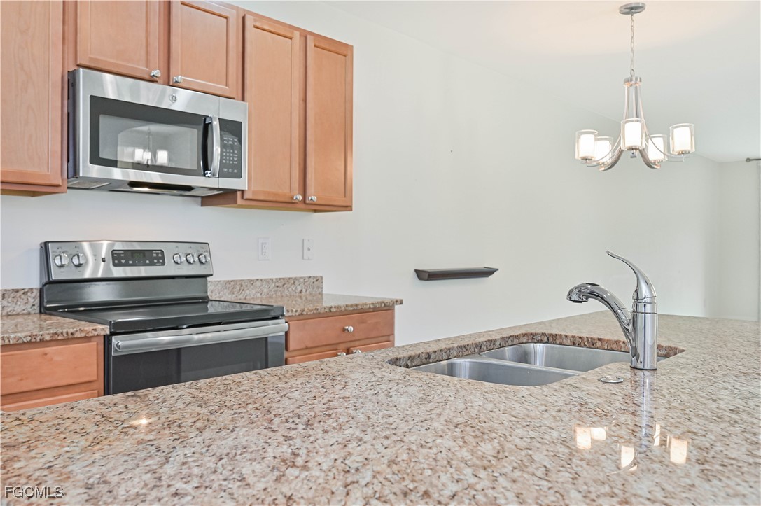 15239 Ligustrum Lane Alva, FL 33920 - Photo 24 of 44 a kitchen with stainless steel appliances granite countertop a sink and a stove