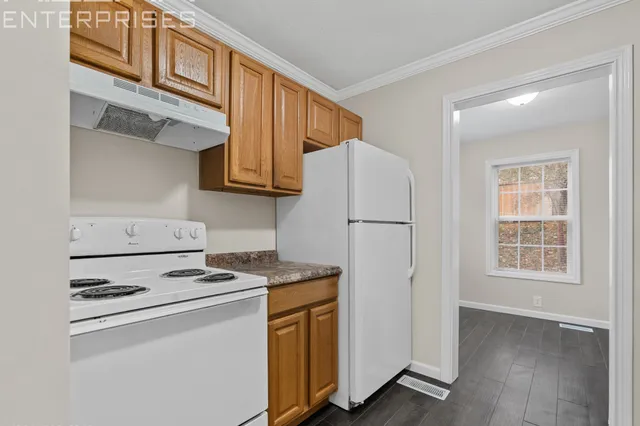 a white refrigerator freezer and a stove sitting inside of a kitchen