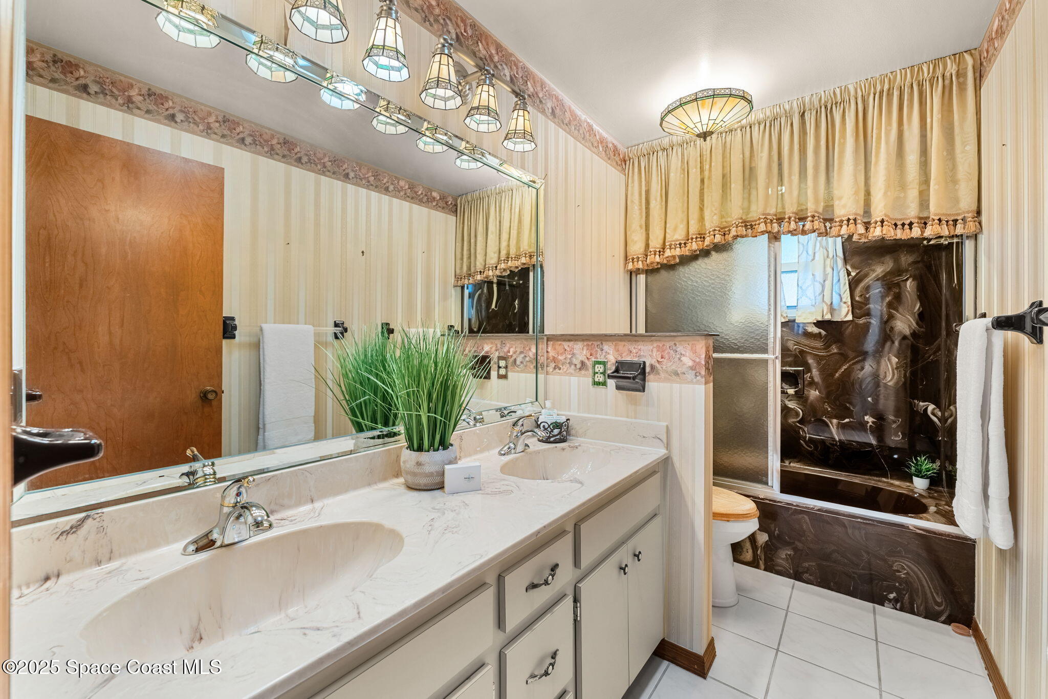 4 Colonial Way Indian Harbour Beach, FL 32937 - Photo 30 of 58 a bathroom with a sink double vanity and a mirror