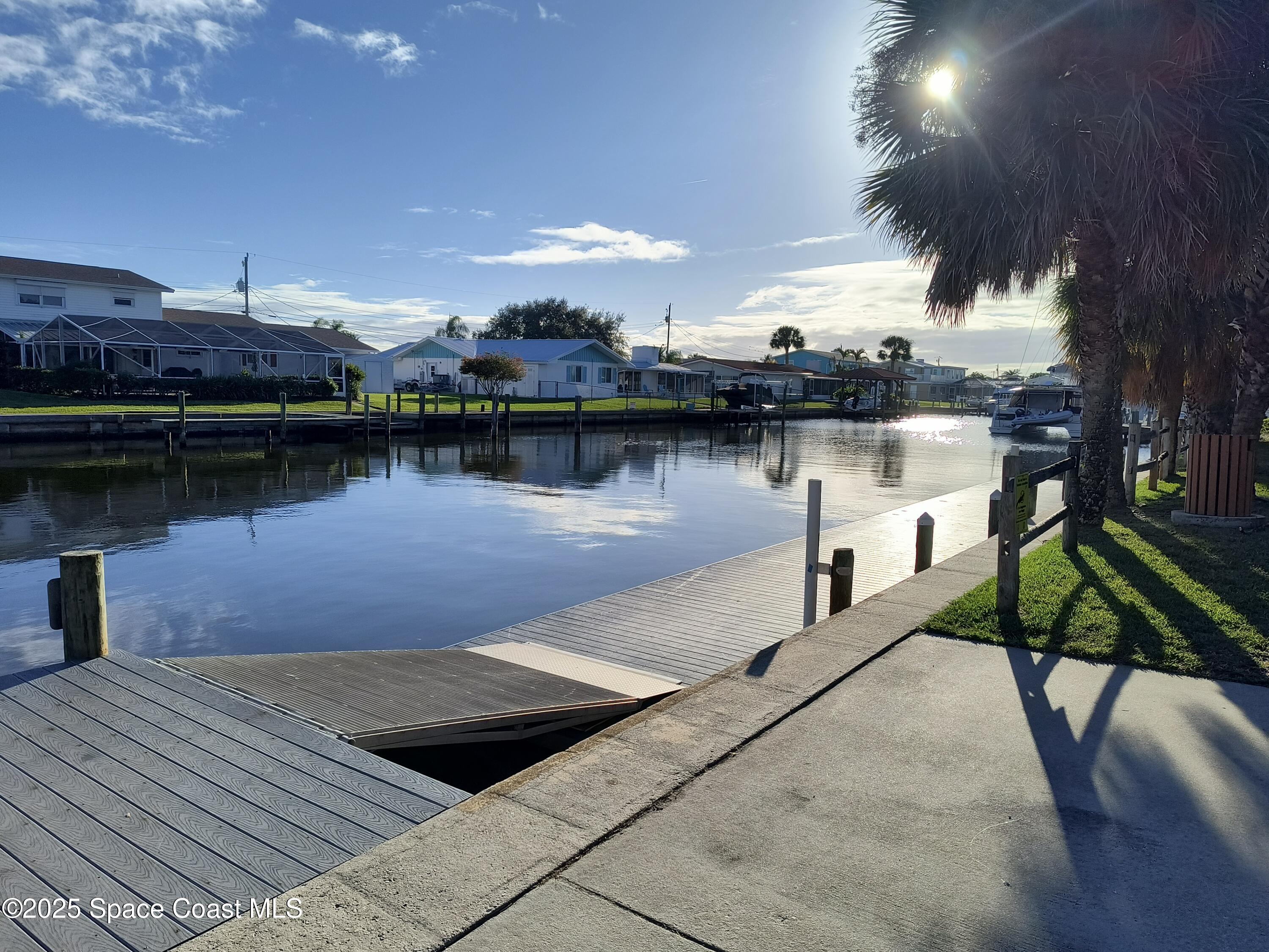 4 Colonial Way Indian Harbour Beach, FL 32937 - Photo 51 of 58 a lake view with a bench under an umbrella