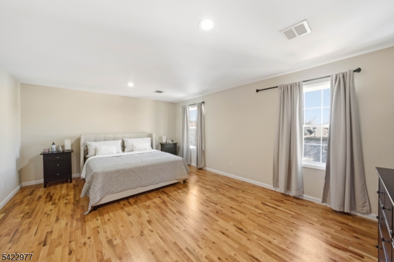 175 North 7th Street Newark, NJ 07107 - Photo 9 of 17 a spacious bedroom with a bed and wooden floor