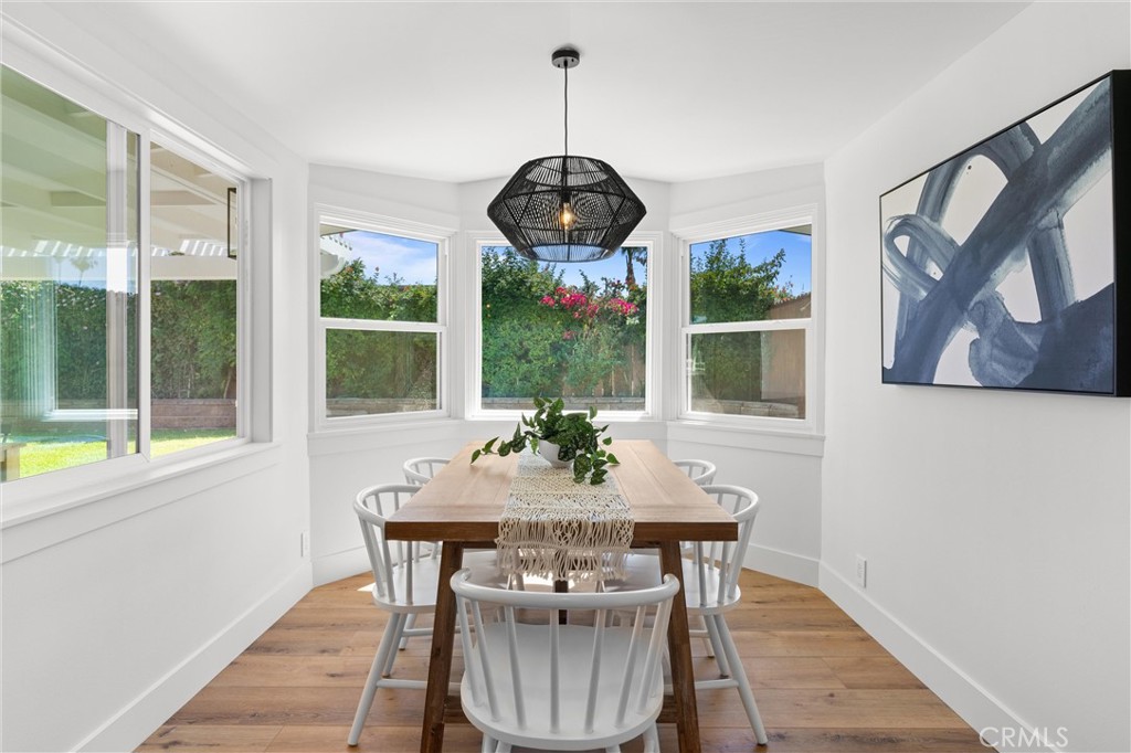 1709 Orcas Drive Costa Mesa, CA 92626 - Photo 11 of 25 a dining room with furniture wooden floor a potted plant and a chandelier