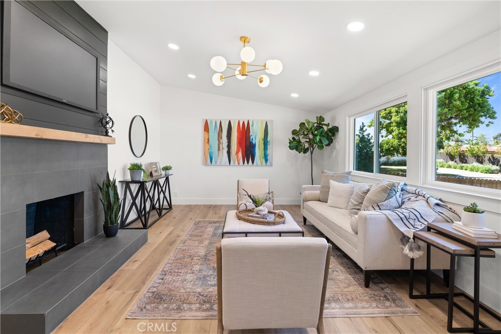 1709 Orcas Drive Costa Mesa, CA 92626 - Photo 3 of 25 a living room with furniture a fireplace and a flat screen tv
