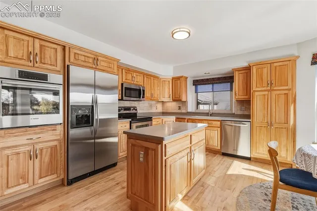 a kitchen with stainless steel appliances granite countertop a refrigerator a stove top oven a sink dishwasher and white cabinets with wooden floor