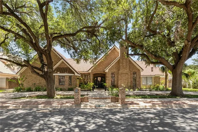 a front view of a house with a tree