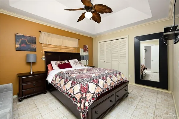 a large bed sitting in a bedroom next to a lamp and a chandelier