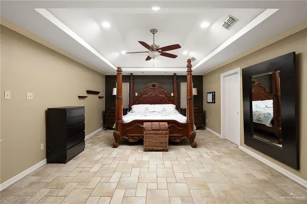 a spacious bedroom with a bed and a chandelier