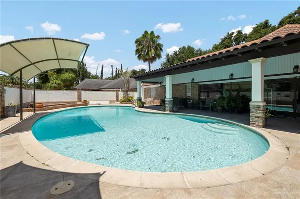 a view of a swimming pool with a yard and seating area