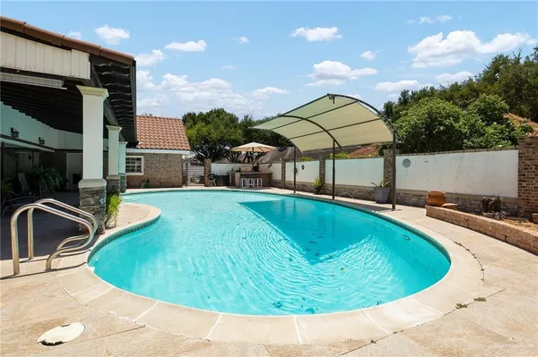 a view of a house with swimming pool and sitting area