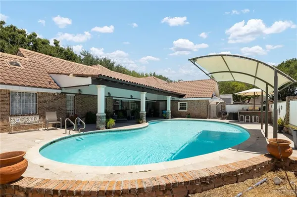 a backyard with potted plants and a table and chair
