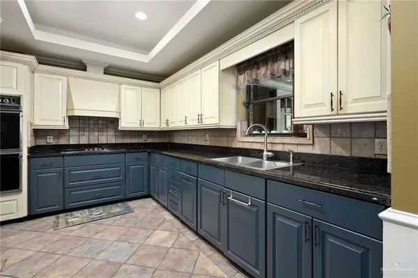 a kitchen with granite countertop a sink stainless steel appliances and cabinets