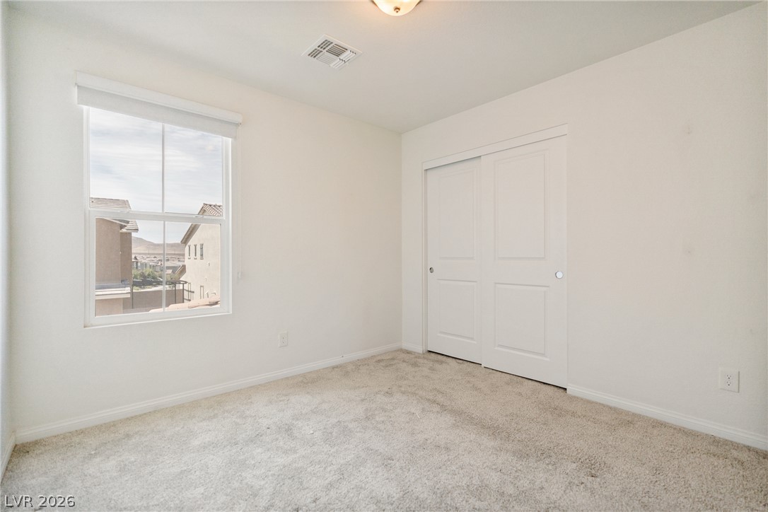 2495 Rofrano Place Henderson, NV 89044 - Photo 10 of 20 Soft carpeting pairs with crisp walls in this versatile, light-filled bedroom space.