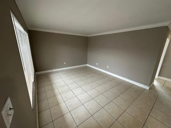 a view of a livingroom with an empty space and a window