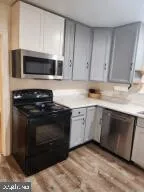 a kitchen with stainless steel appliances kitchen island granite countertop a stove a sink and a refrigerator