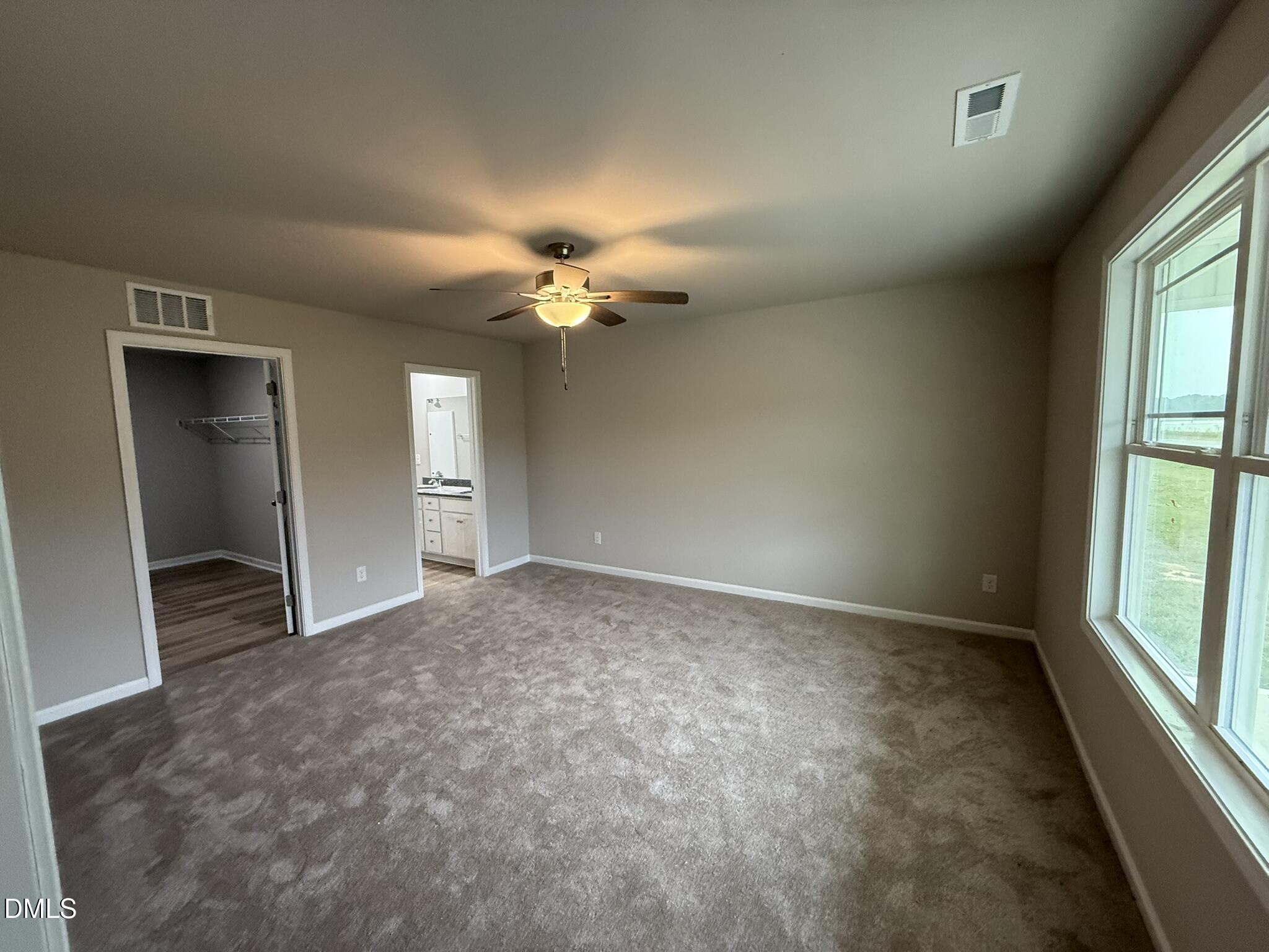 1843 Old Kenly Road Kenly, NC 27542 - Photo 8 of 16 an empty room with chandelier fan and windows