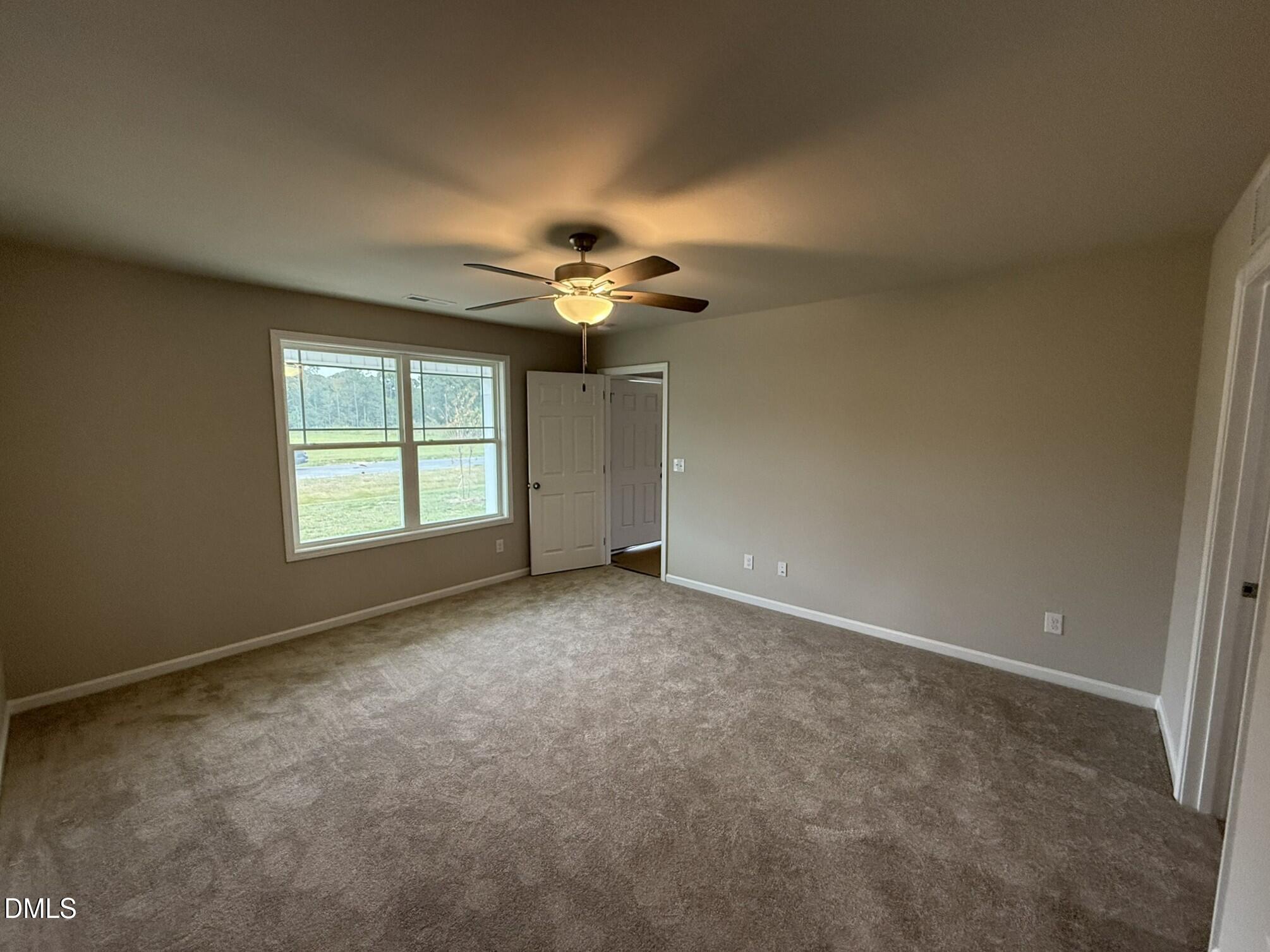 1843 Old Kenly Road Kenly, NC 27542 - Photo 9 of 16 an empty room with a ceiling fan and a window