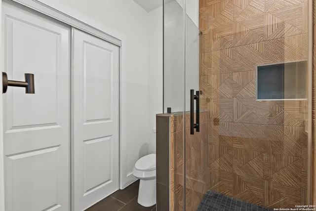 a bathroom with a toilet and a shower