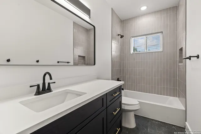 a bathroom with a sink mirror toilet and bathtub