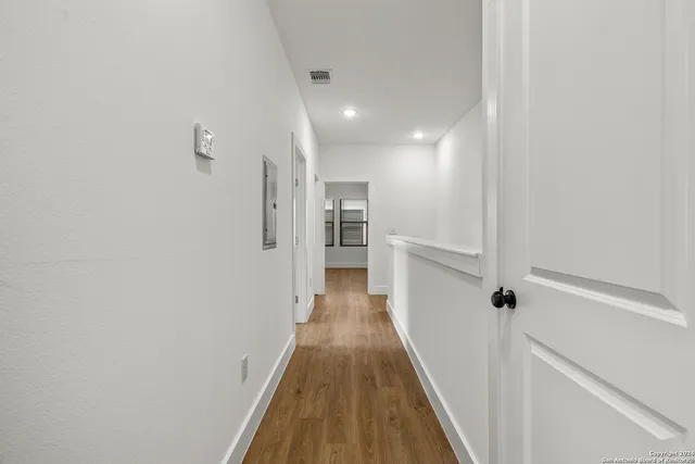 a view of a hallway with wooden floor and staircase