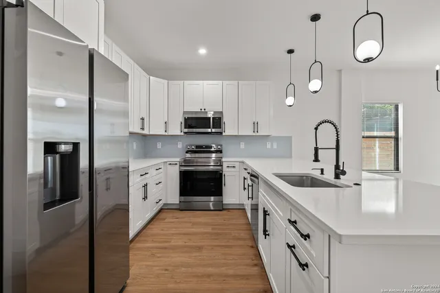 a kitchen with kitchen island granite countertop a sink stainless steel appliances and cabinets