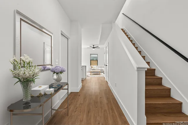 a view of a hallway with wooden floor and staircase