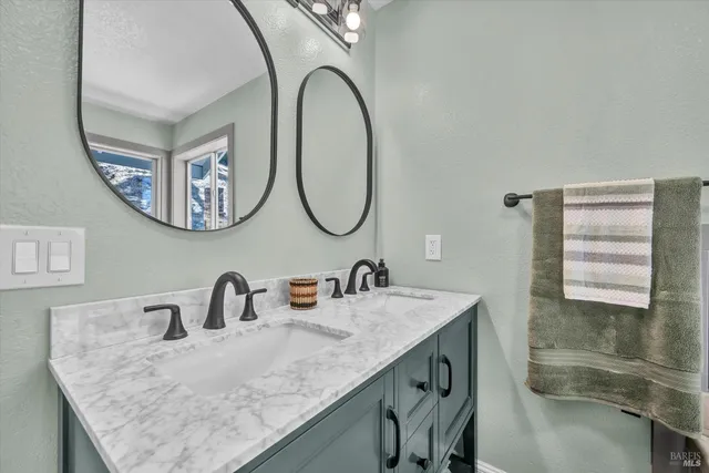 a bathroom with a granite countertop toilet sink and mirror