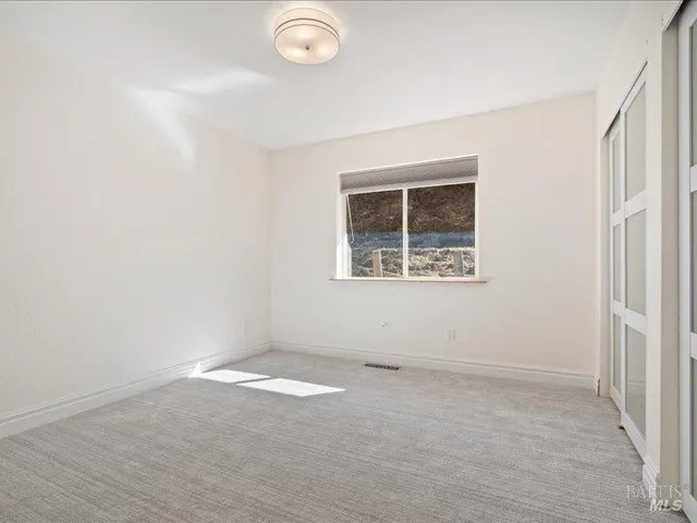 a bathroom with a granite countertop toilet sink and mirror