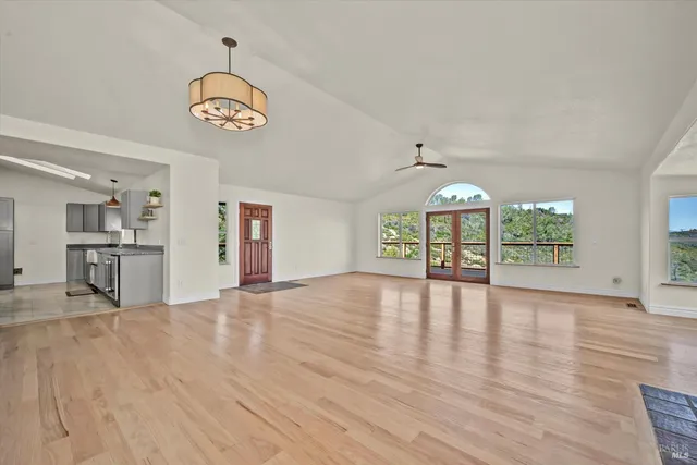 a view of empty room with wooden floor and window